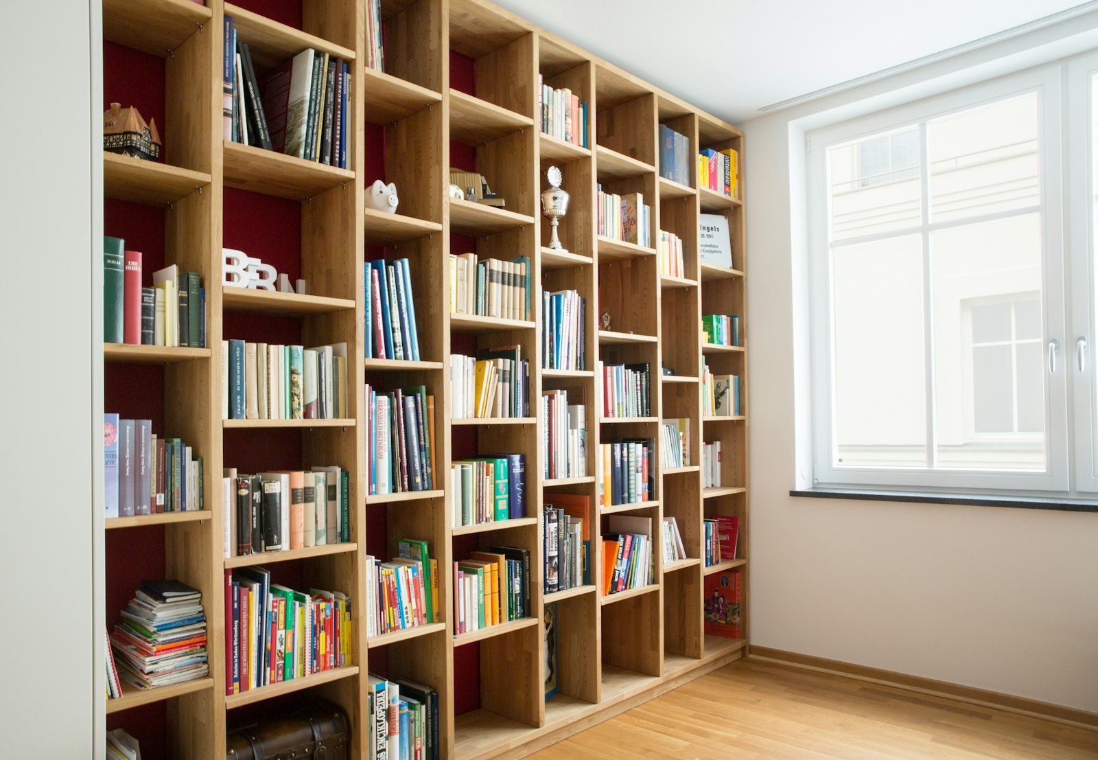 Bibliothèque sur-mesure en bois près d'une fenêtre